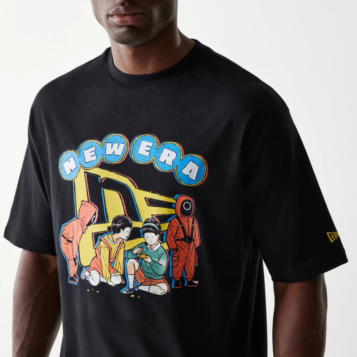 New Era Netflix Squid Game Black Oversized T-Shirt, front view on a model showing a graphic of Squid Game characters beneath a stylised New Era logo on the chest and a yellow New Era logo embroidered on the left sleeve.