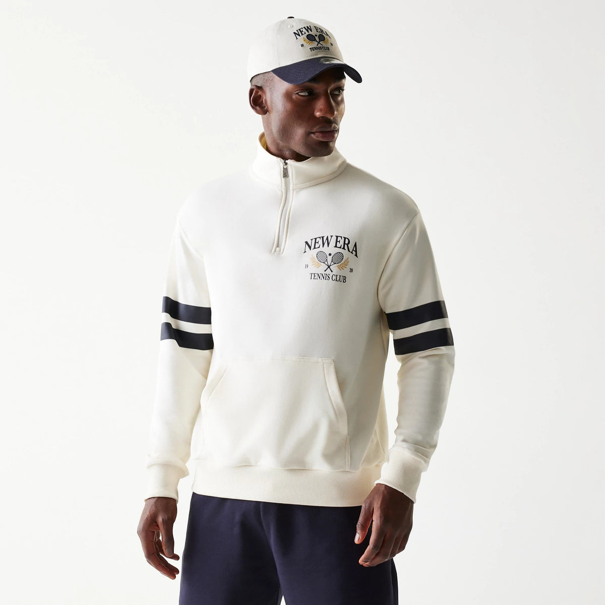 New Era Open White Oversized 1/4 Zip Sweater, front view on a model featuring the embroidered New Era Tennis Club logo with rackets on the left chest, zip collar, and black striped on the sleeves.