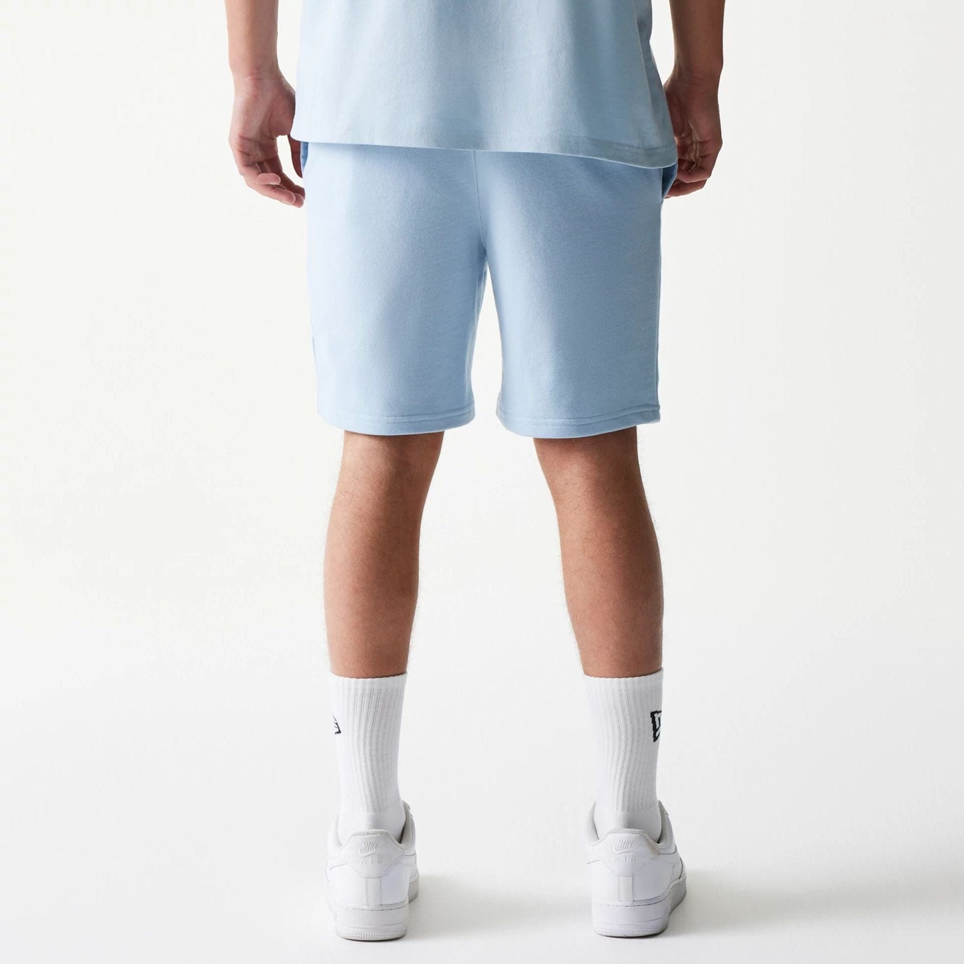 The model is wearing this MLB League Essential Midi New York Yankees Shorts in pastel blue. 2