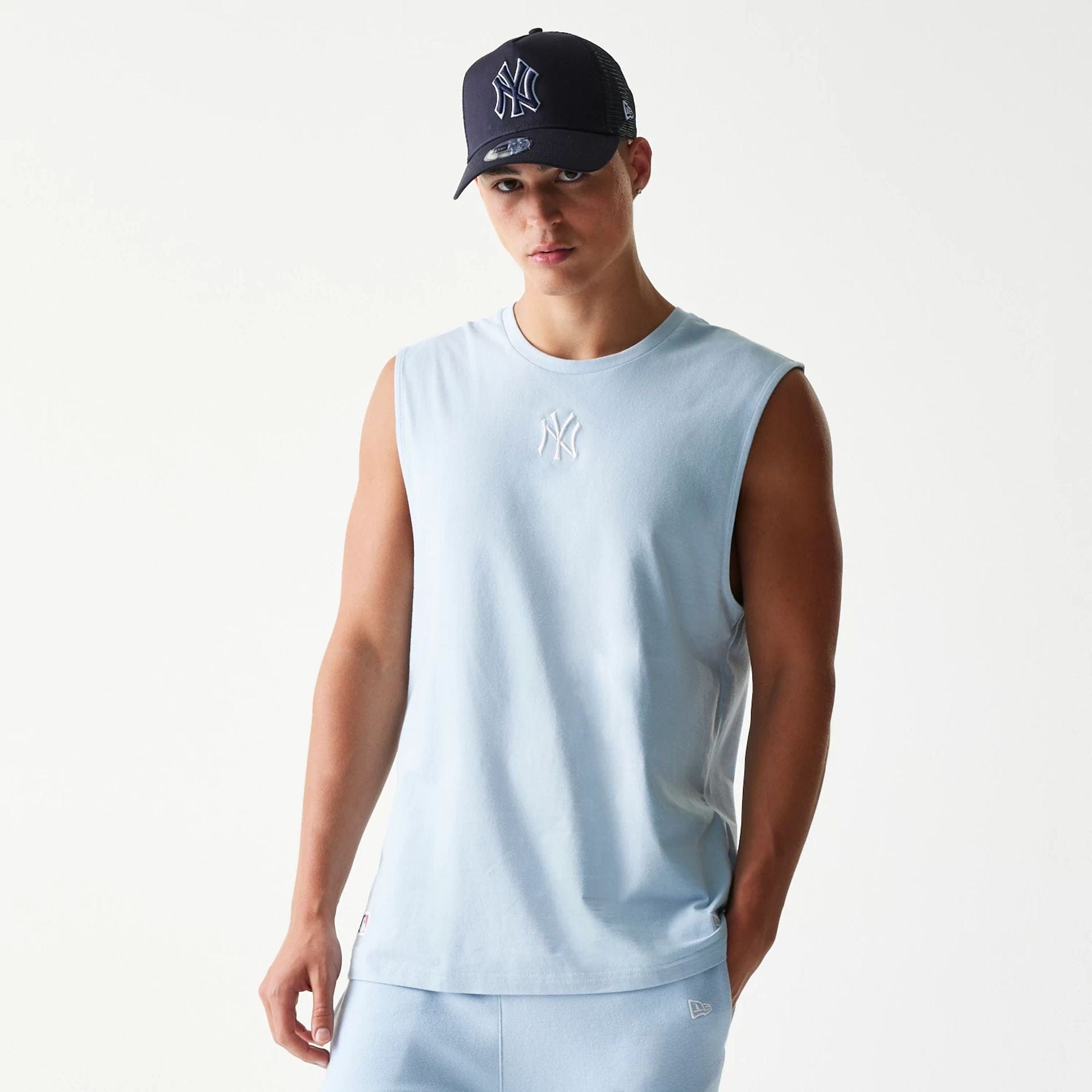 The model is wearing this MLB League Essential New York Yankees Sleeveless T-Shirt in pastel blue. 1