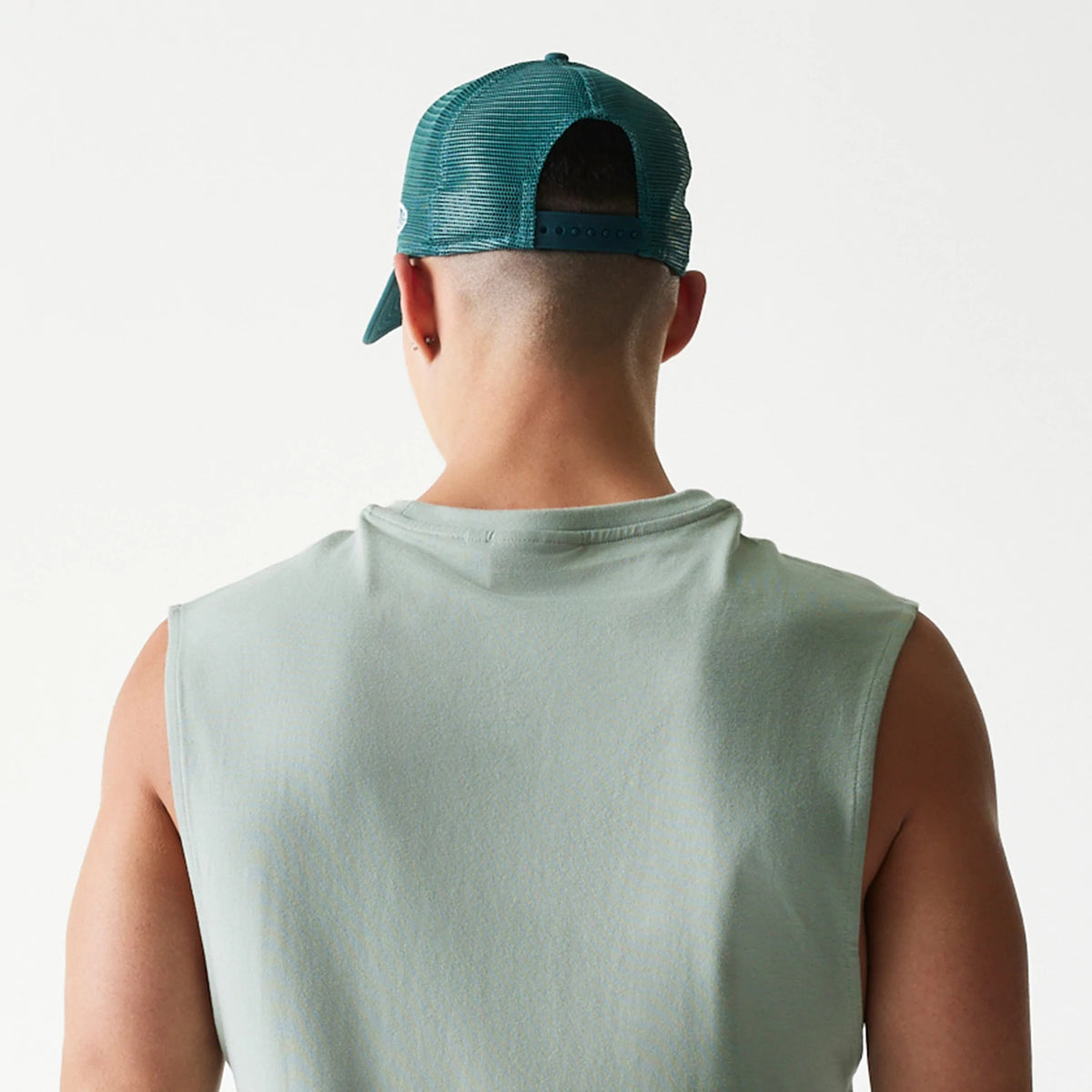 New Era LA Dodgers MLB Pastel Green Sleeveless T-Shirt, back view on a model matched with a green mesh cap showing the plain pastel green back and the cut-off sleeves for a relaxed style.