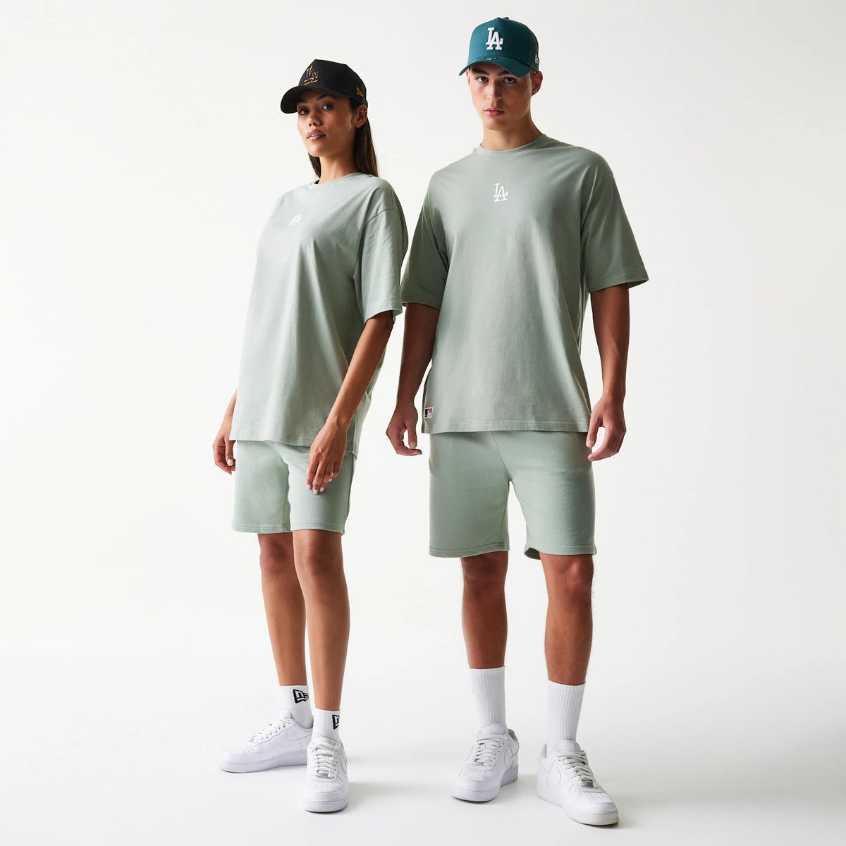 New Era LA Dodgers MLB Midi Pastel Green Oversized T-Shirt, front view on two models wearing matching pastel green shorts and caps, featuring a white embroidered LA logo in the centre of the chest of the relaxed-fit t-shirt.
