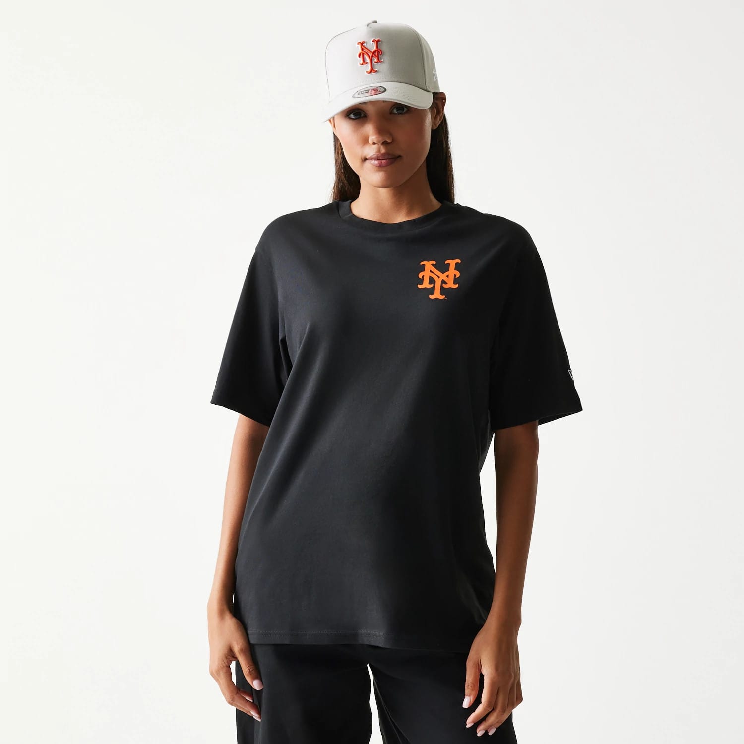 New Era New York Mets MLB Food Graphic Black T-Shirt, front view on-model showing an orange embroidered New York Mets logo on the left chest, styled with a grey cap featuring a matching embroidered team logo.