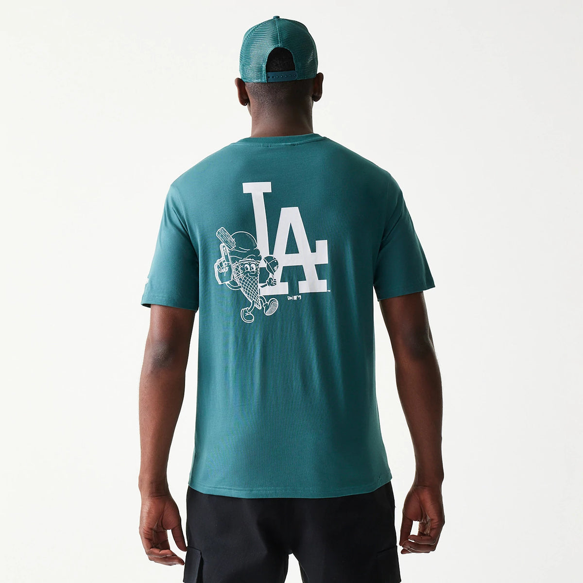 New Era LA Dodgers MLB Food Graphic Dark Green T-Shirt, back view on a model wearing black shorts and a matching cap, featuring a white printed LA logo and a cartoon food graphic on the upper back.