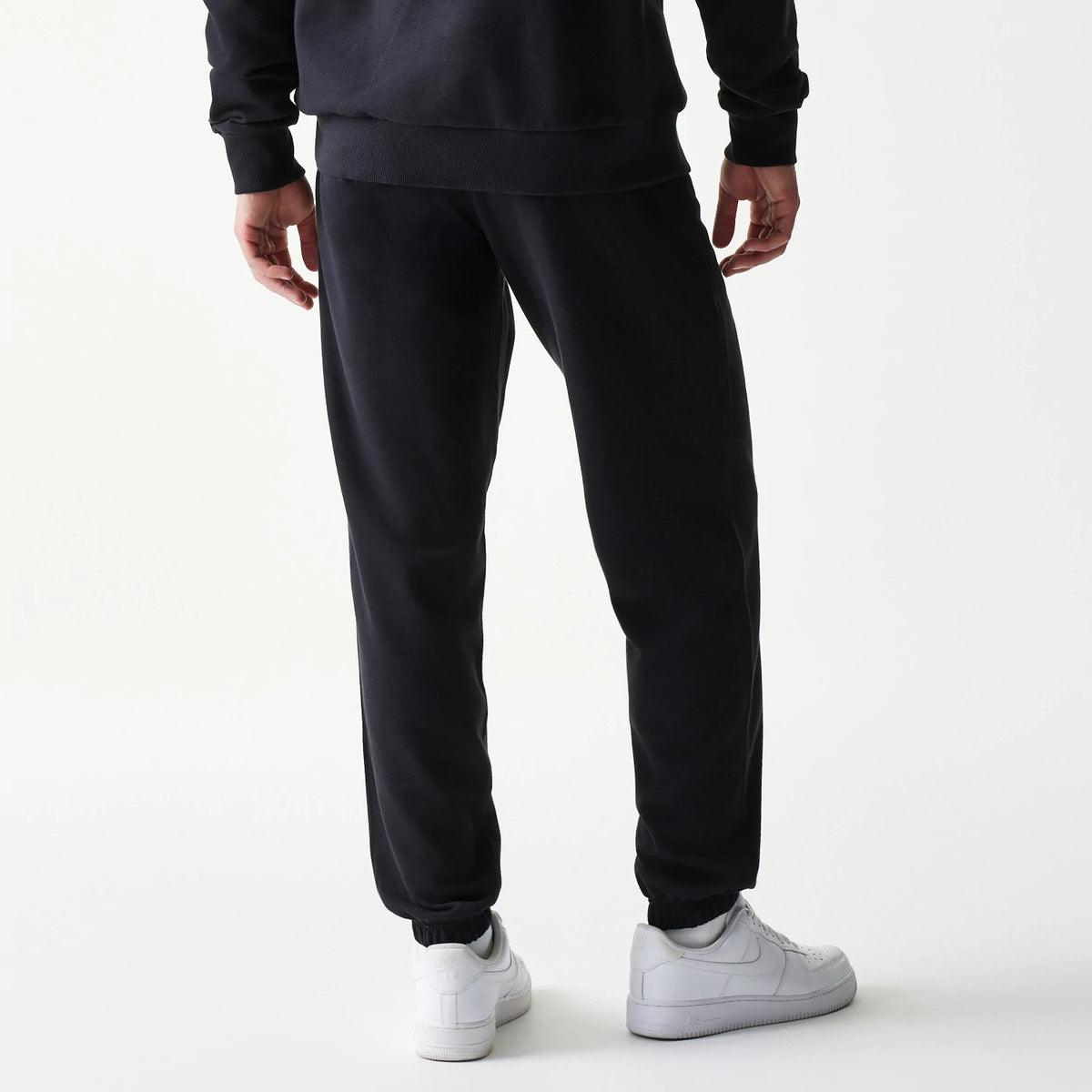 New Era Chicago Bulls NBA League Essential Black Joggers, back view on a model showing the elasticated cuffs and a relaxed fit, with seam down the legs.