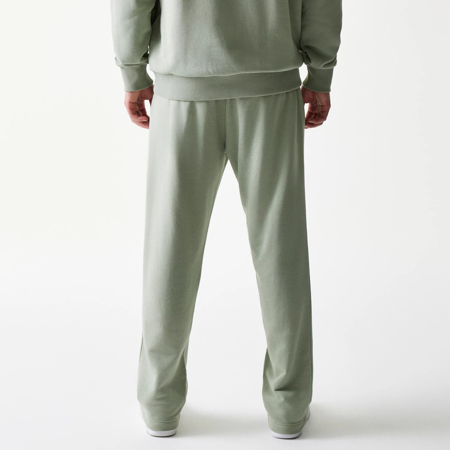 New Era LA Lakers NBA Pastel Green Straight Leg Joggers, back view on a model showing the relaxed fit and elasticated waist, with the soft pastel green fabric extending to the straight-cut cuffs.