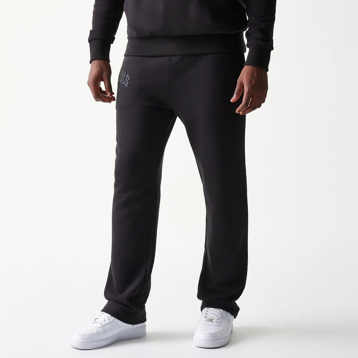 New Era Chicago Bulls NBA Black Straight Leg Joggers, front view on a model with grey team logo detail on the left pocket and white trainers, showcasing the simple straight leg cut and ribbed waistband.