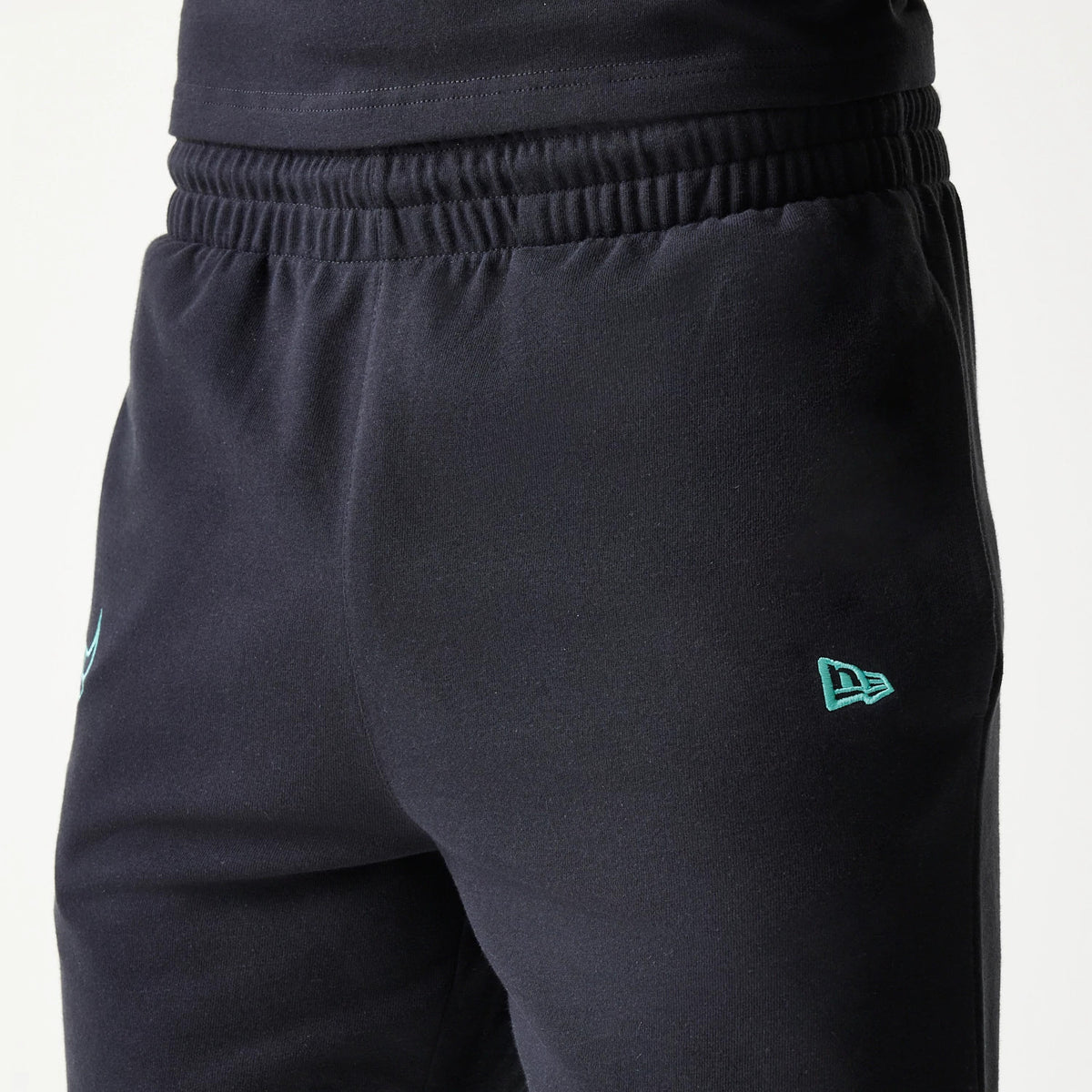New Era Chicago Bulls NBA League Essential Black Shorts, front view showing the dark black fabric with an elasticated waistband, light blue embroidered New Era flag logo near the hem on the leg.