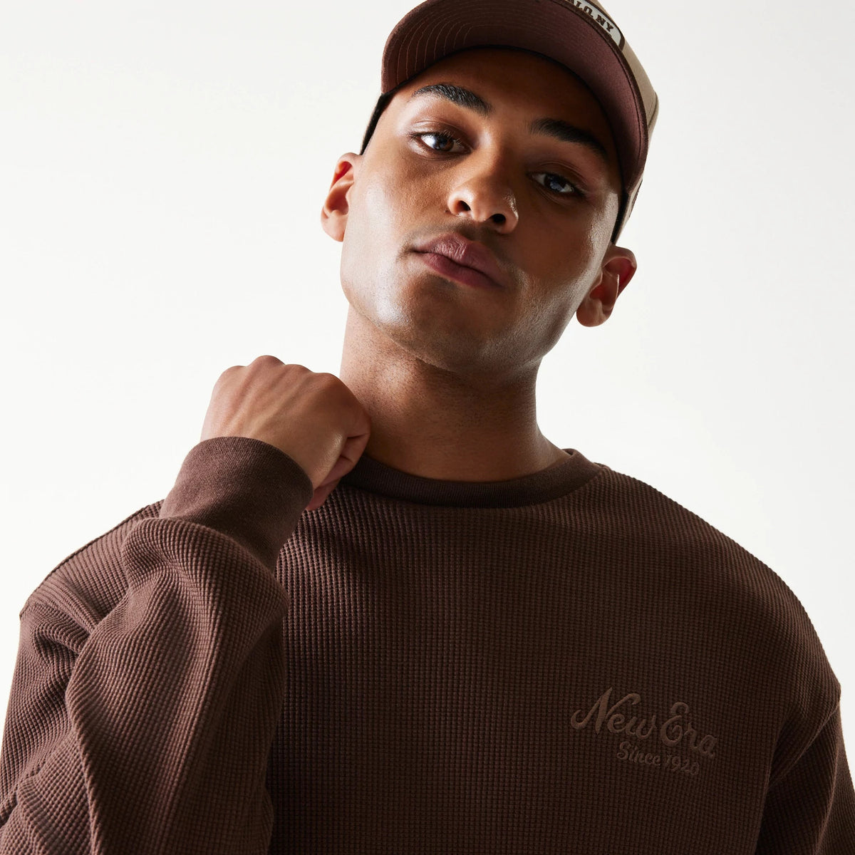 The model is wearing this New Era Script Waffle Crew Neck Sweater in brown. 8