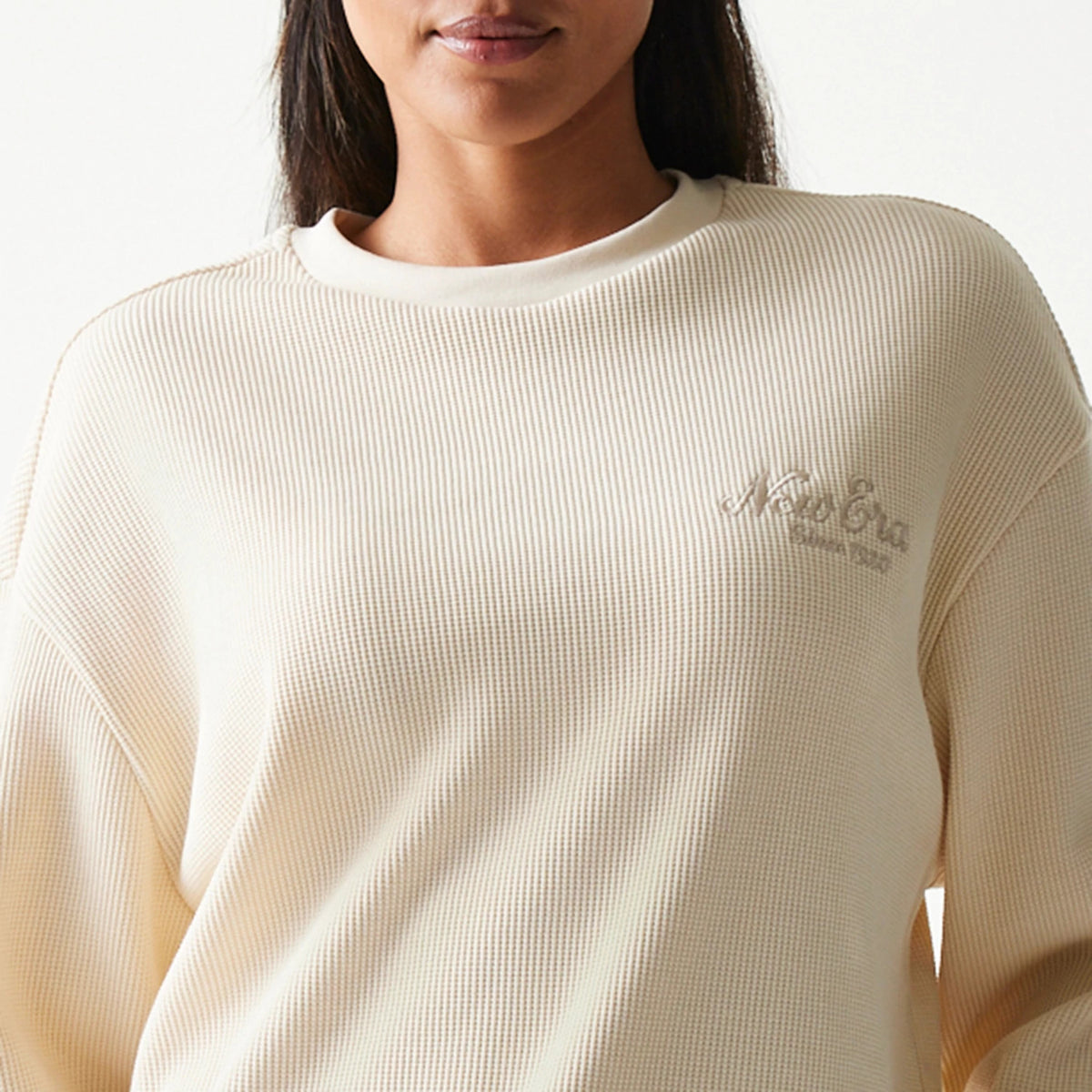 New Era Script Waffle Light Beige Crew Neck Sweater, front view showing the embossed New Era script logo on the left chest, featuring a textured waffle knit pattern and a round collar.