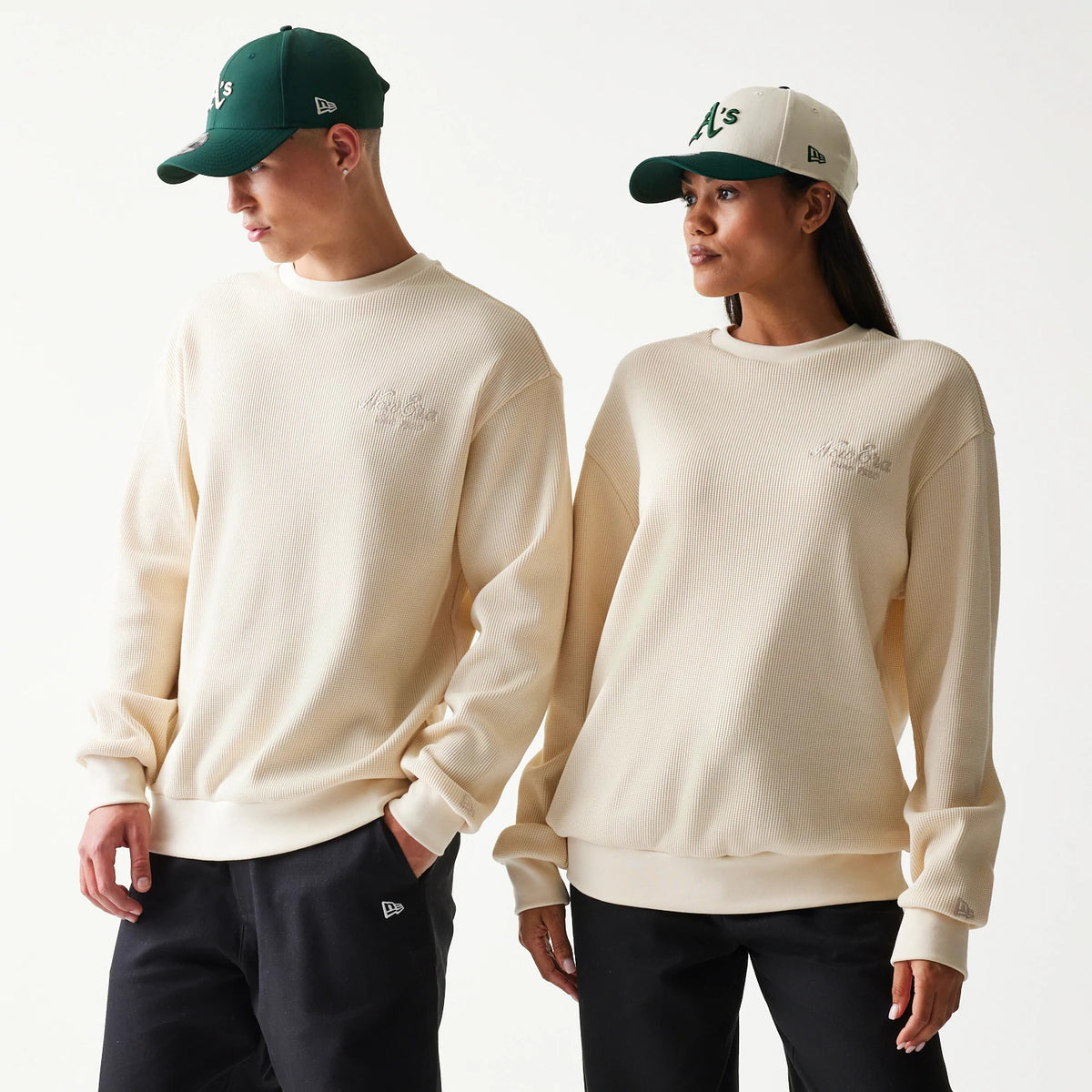 New Era Script Waffle Light Beige Crew Neck Sweater, front view on a model featuring a embroidered script logo on the left chest, ribbed cuffs and hem, and a textured waffle fabric pattern.