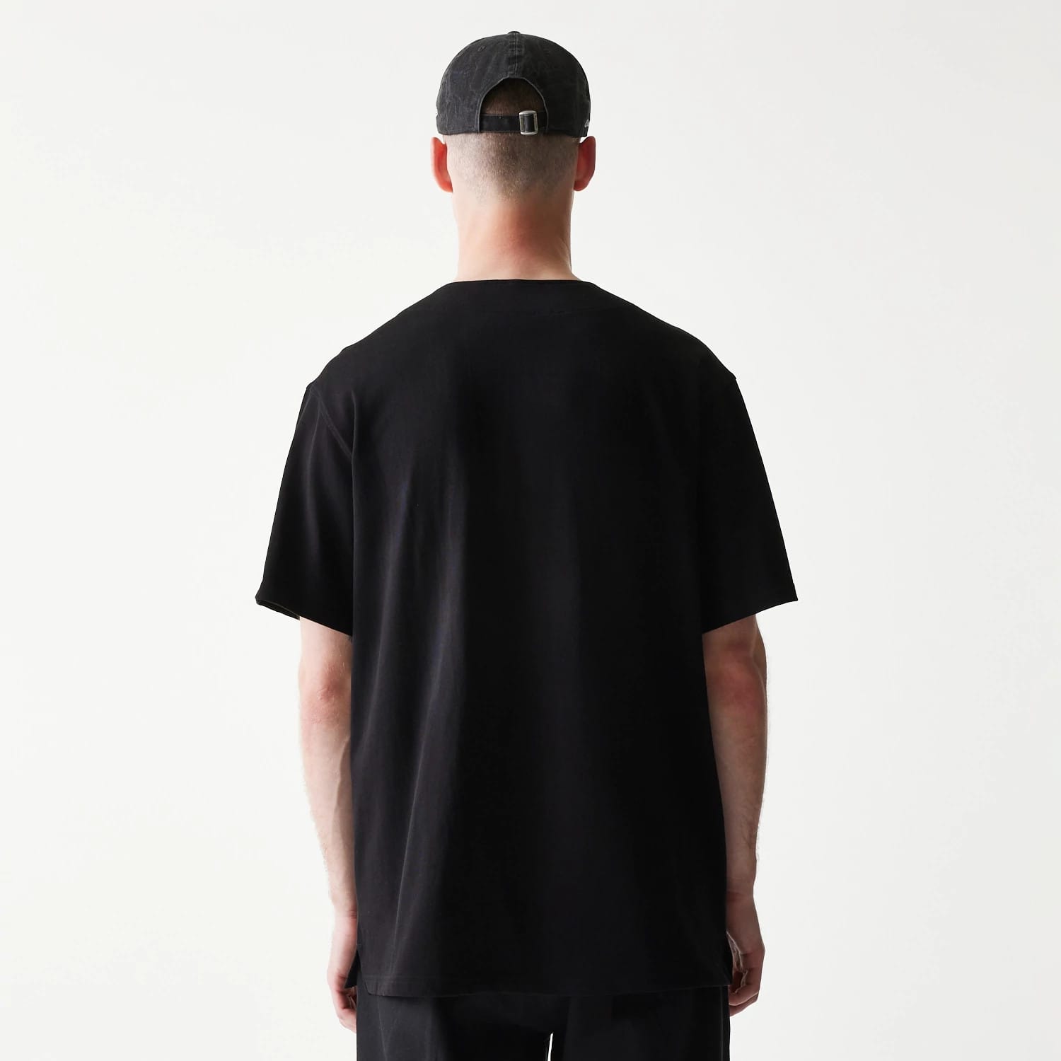 The model is wearing this New Era Open Heritage Script T-Shirt in black. 2