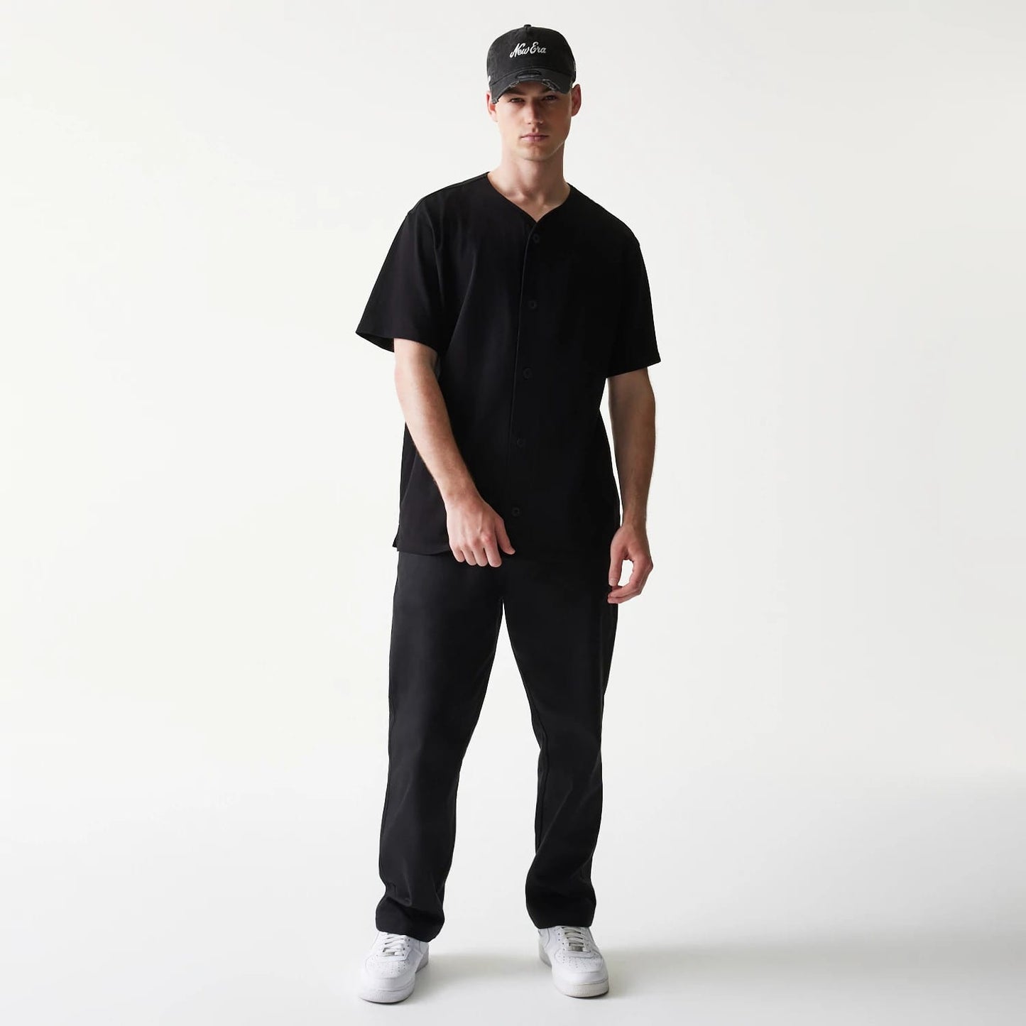 The model is wearing this New Era Open Heritage Script T-Shirt in black. 8