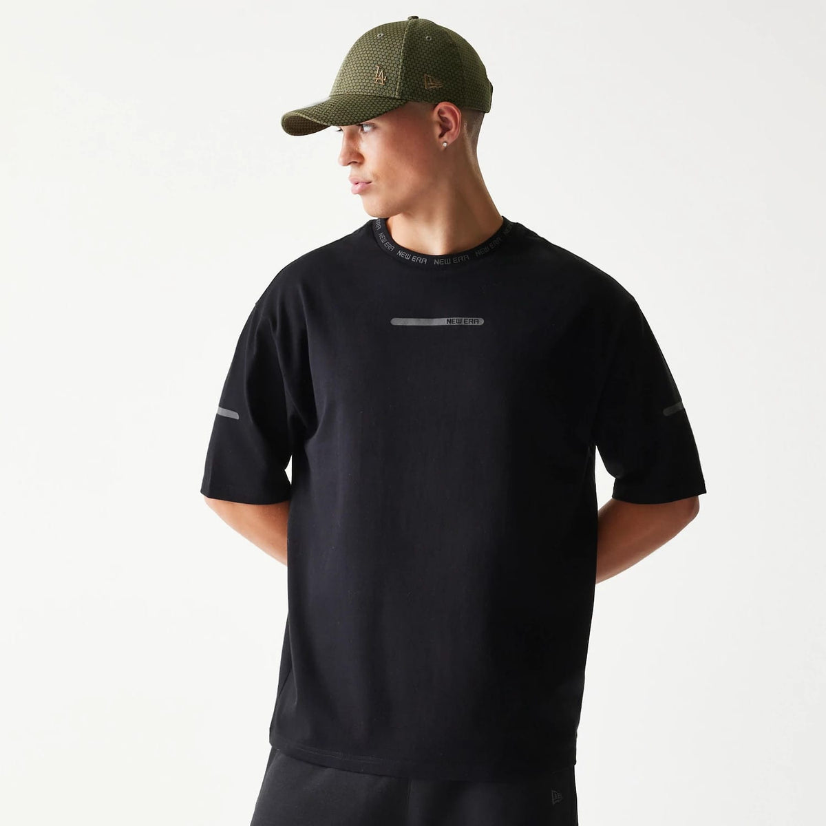 The model is wearing this New Era Tech Oversized T-Shirt in black. 1