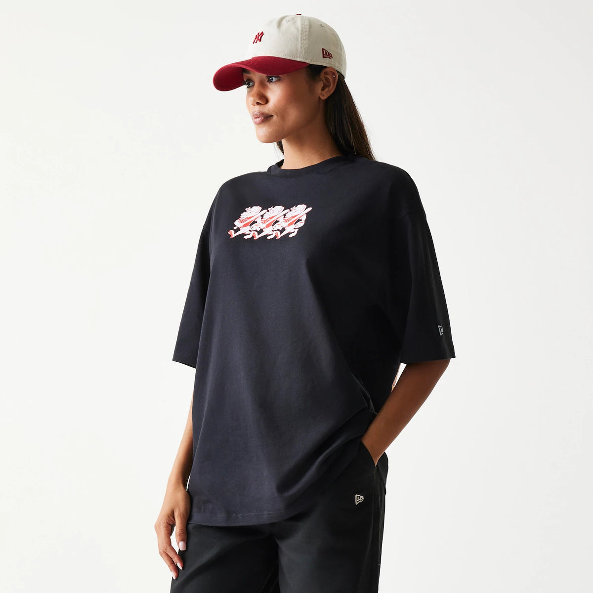 New Era Baseball Cows Character Graphic Black Oversized T-Shirt, front view on-model featuring a playful white and red cow character graphic across the chest, with an embroidered New Era logo on the left sleeve.