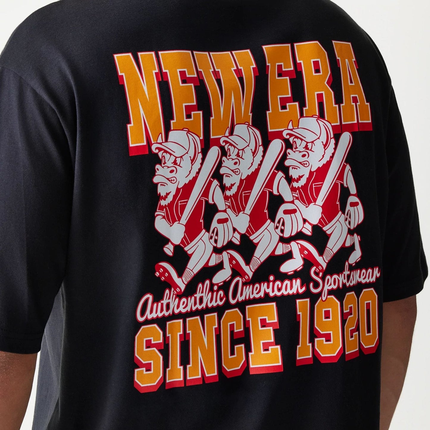 New Era Baseball Cows Character Graphic Black Oversized T-Shirt, back view showing yellow and red New Era lettering, animated cow characters with baseball bats, and the phrase Authentic American Sportswear Since 1920 in a layered graphic.