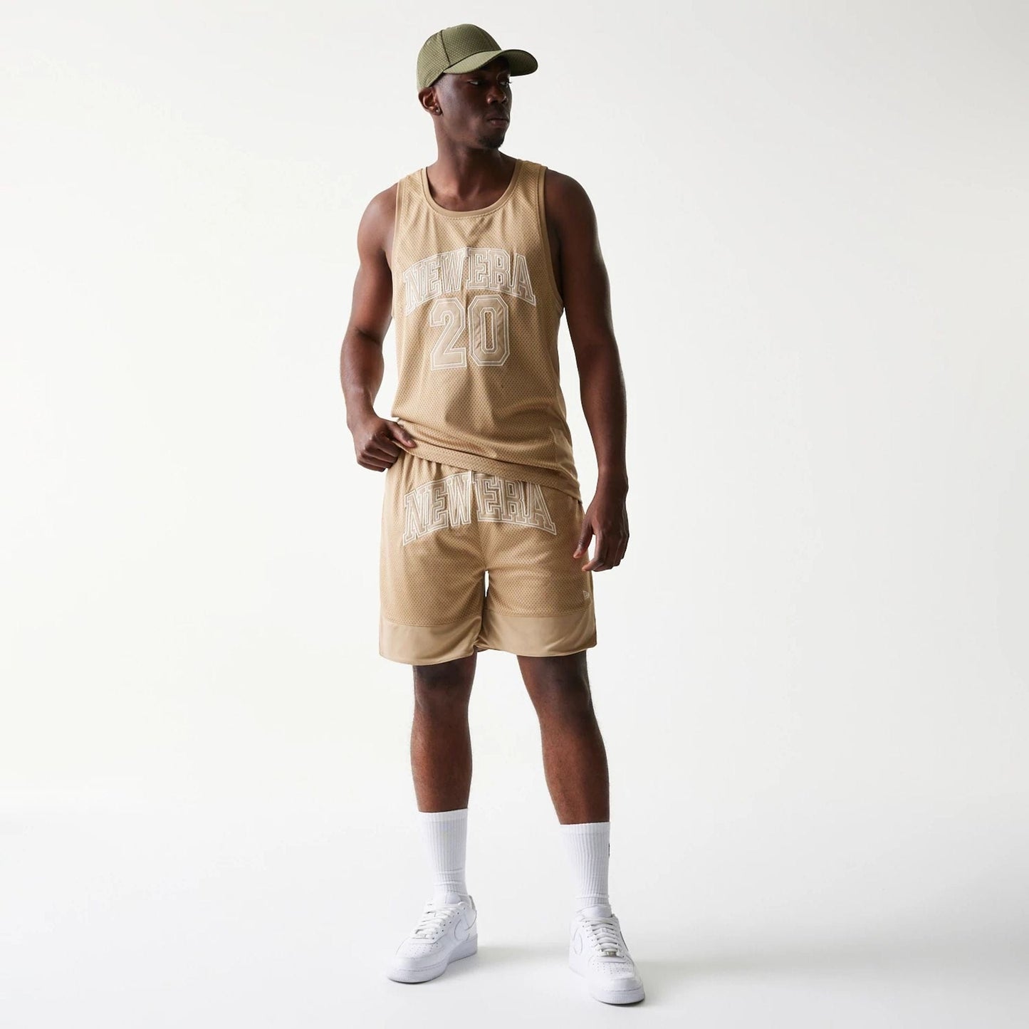The model is wearing this New Era Mesh Graphic Oversized Shorts in light beige. 8