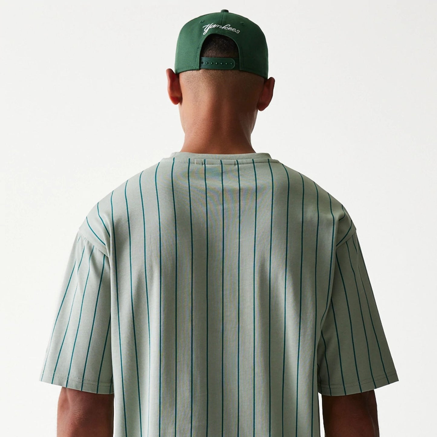 The model is wearing this New Era Pinstripe Oversized T-Shirt in pastel green. 7