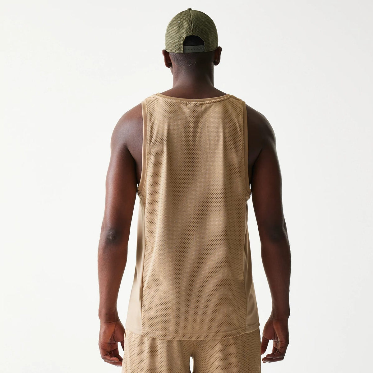 New Era Mesh Light Beige Tank Top, back view on a model showing the texture of the light beige mesh fabric and relaxed fit across the shoulders and waist for a casual athletic look.
