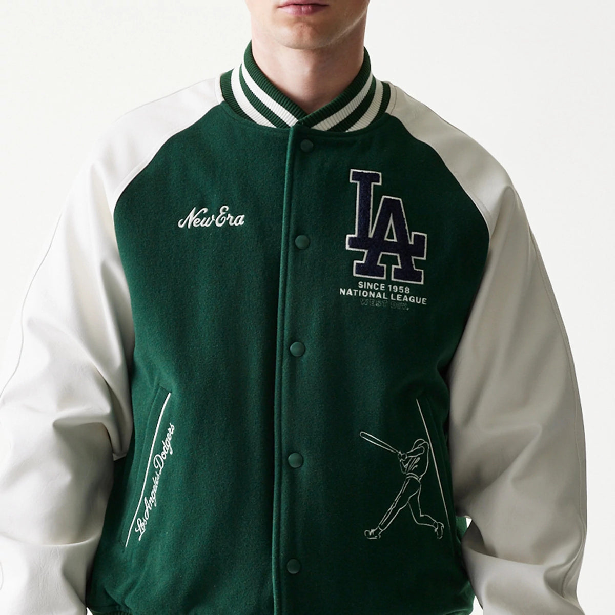 New Era LA Dodgers MLB Dark Green Varsity Jacket, front view on-model showing the dark green body with New Era embroidered on the left chest, large LA logo on the right chest, white sleeves, and script text on the pocket area.