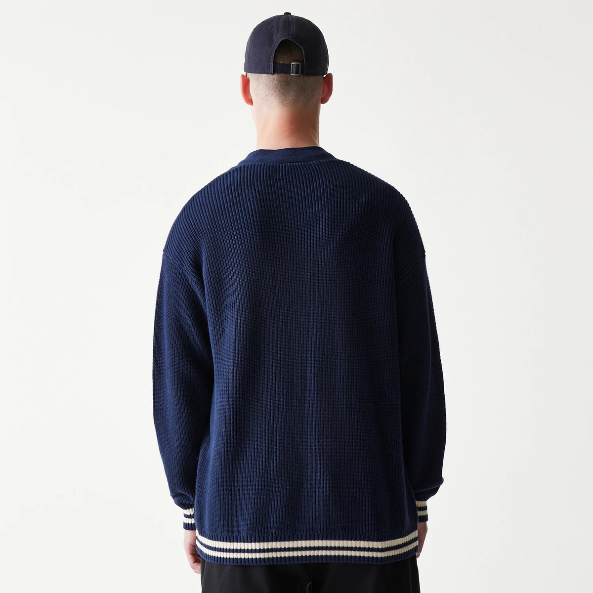 New Era New York Yankees MLB Collegiate Navy Cardigan, rear view on a model with a navy ribbed texture, showcasing striped cuffs and hem in contrasting white for a classic varsity look.