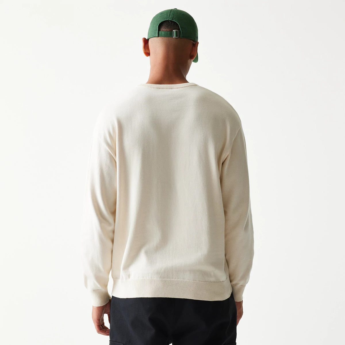 New Era LA Dodgers MLB Essential Open White Knitted Sweater, back view on a model highlighting the white fabric and ribbed hem, with long sleeves providing a clean and classic look.