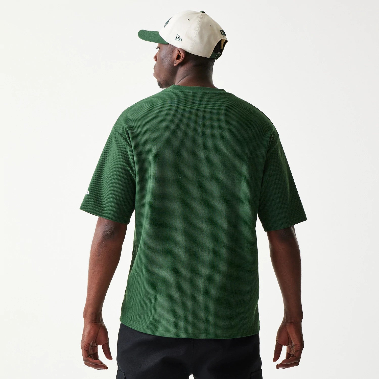New Era LA Dodgers MLB Waffle Dark Green Oversized T-Shirt, back view on a model with a neutral cap, showcasing the textured dark green fabric and short sleeves with a small embroidered logo on the left sleeve.