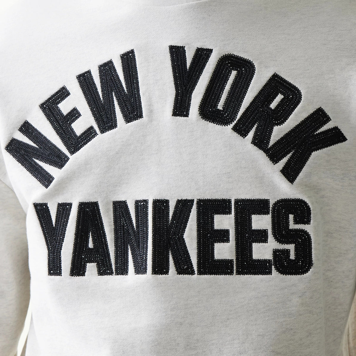 New Era New York Yankees MLB Graphic Pastel Grey Oversized Crew Neck Sweater, front view showing black embroidered New York Yankees lettering across the chest against the light pastel grey fabric.