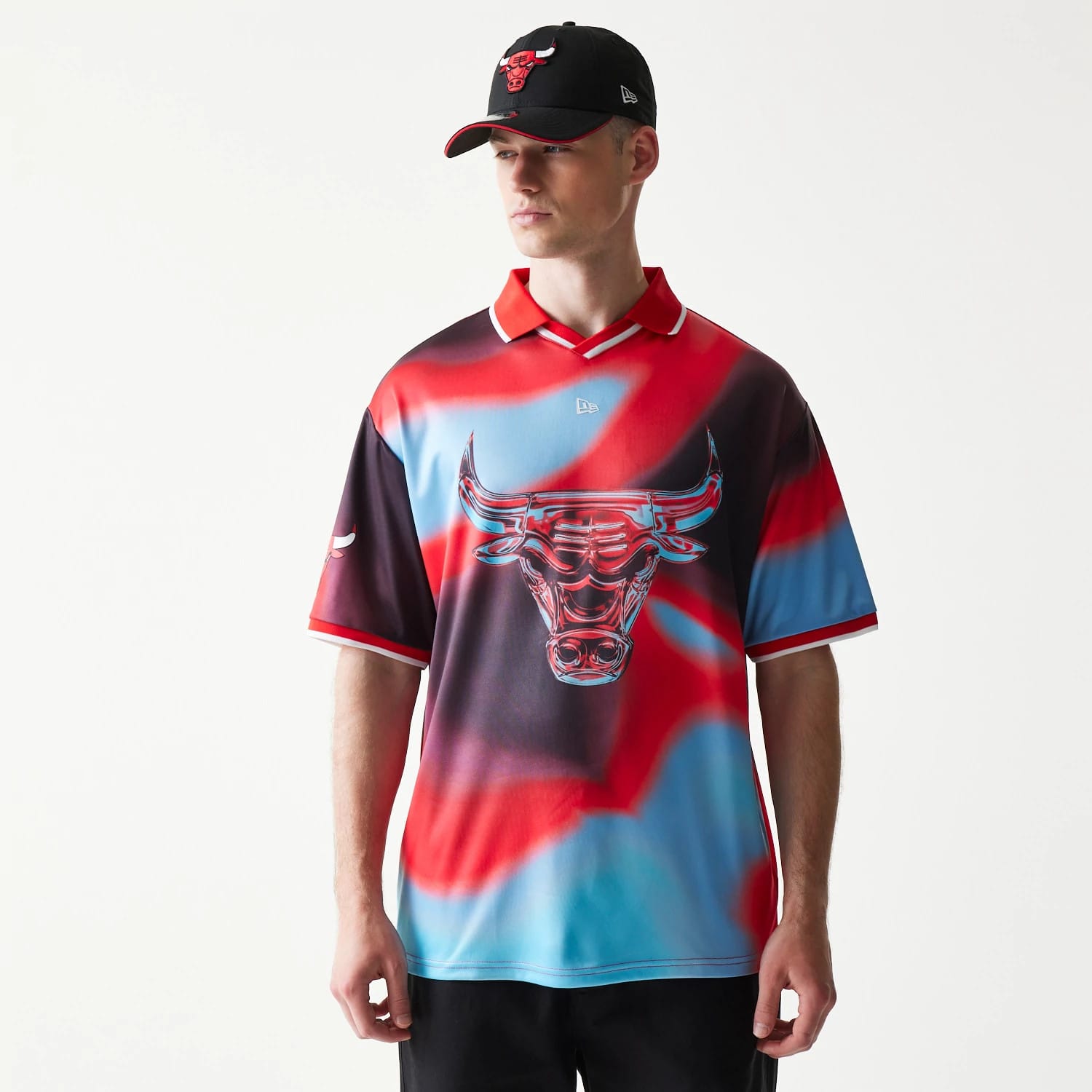 New Era Chicago Bulls NBA All Over Print Red T-Shirt, front view on-model showing an oversized red and blue graphic of a bull's head across the chest, with an embroidered New Era logo centred on the upper chest and contrasting red collar.