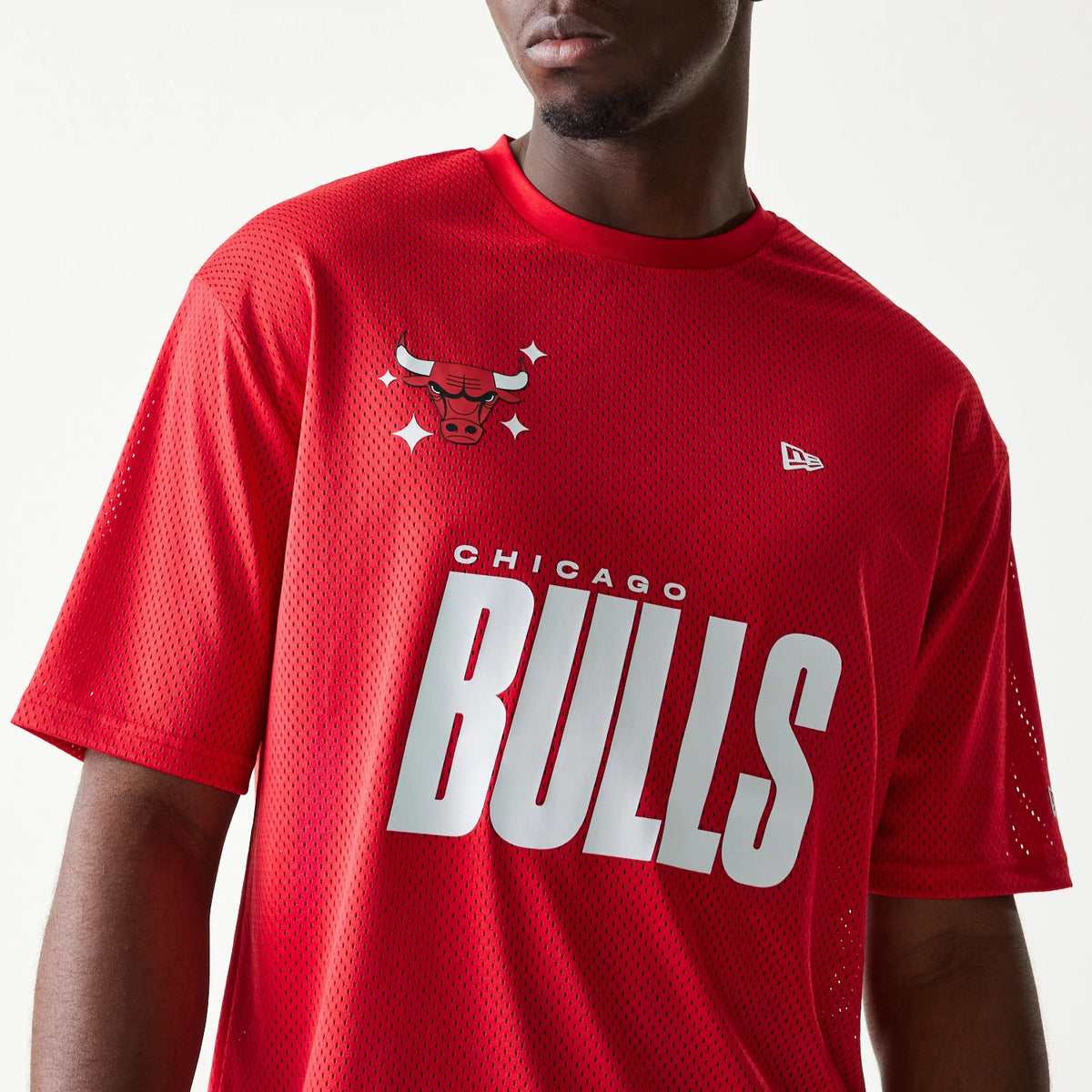 New Era Chicago Bulls NBA Graphic Mesh Red T-Shirt, front view on a model showing a white BULLS print across the chest, the bull graphic with stars above, and an embroidered New Era logo on the upper right.