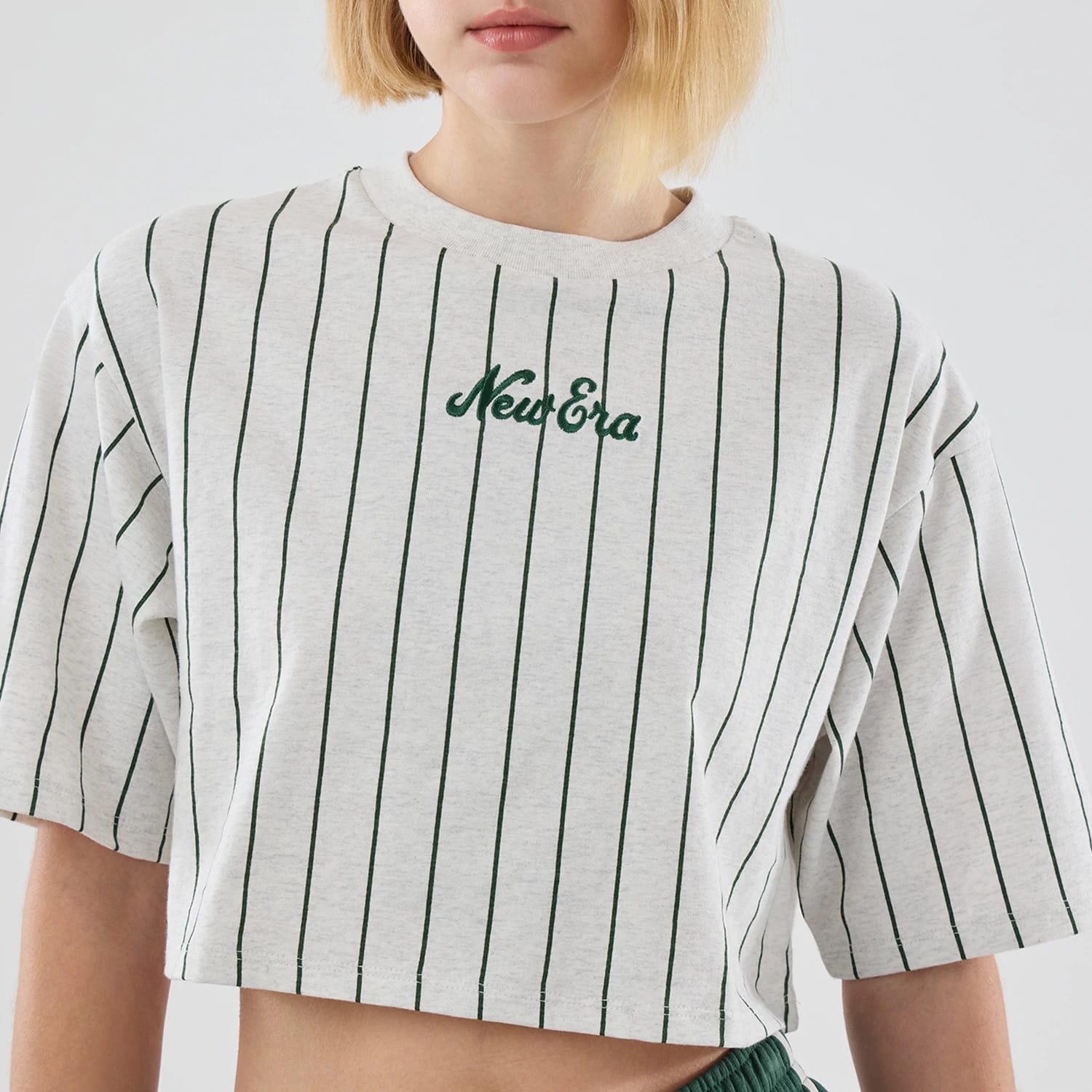 The model is wearing this Womens New Era Pinstripe Cropped T-shirt in pastel grey. 4