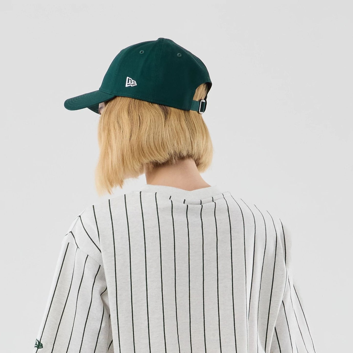 The model is wearing this Womens New Era Pinstripe Cropped T-shirt in pastel grey. 7