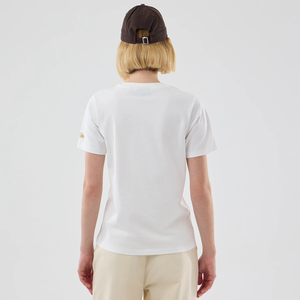 New Era New York Yankees Womens MLB Infill White T-shirt, back view on a model wearing a black cap, showing a plain white back with a small gold embroidered New Era logo on the sleeve.