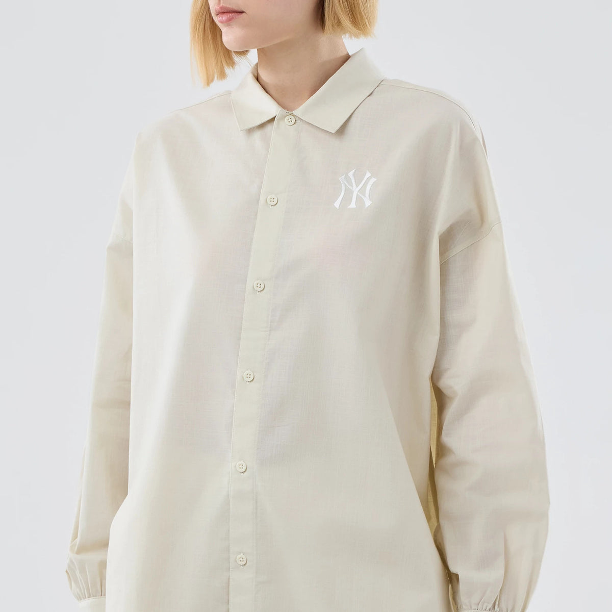 New Era New York Yankees Womens MLB Shirt Cream Long Sleeve Shirt, front view on a model featuring a white embroidered NY logo on the left chest, button-down closure and relaxed fit sleeves with elasticated cuffs.