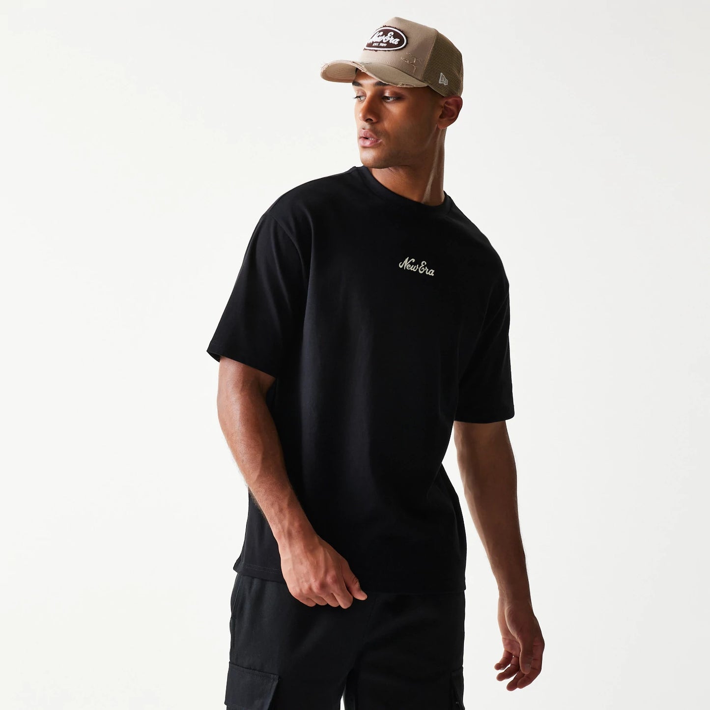 The model is wearing this New Era Heritage Script T-Shirt in black. 8