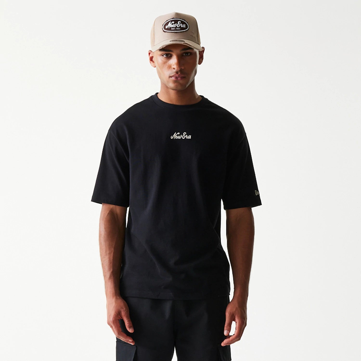 The model is wearing this New Era Heritage Script T-Shirt in black. 3