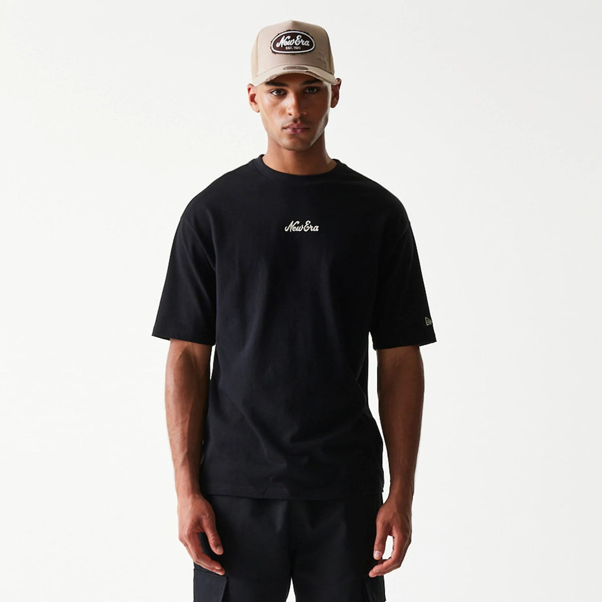 The model is wearing this New Era Heritage Script T-Shirt in black. 3