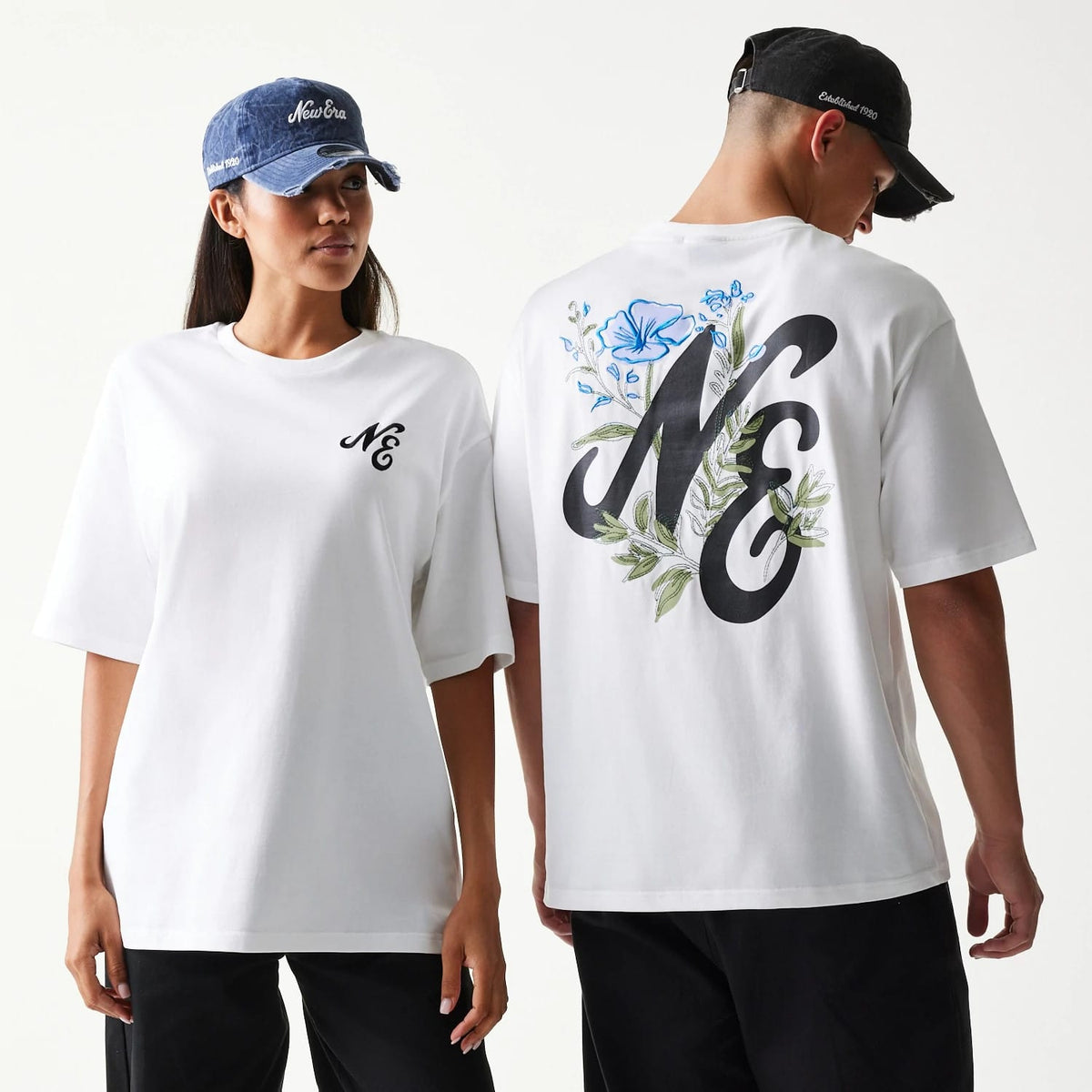 The model is wearing this New Era Floral Graphic Oversized T-Shirt in white. 1