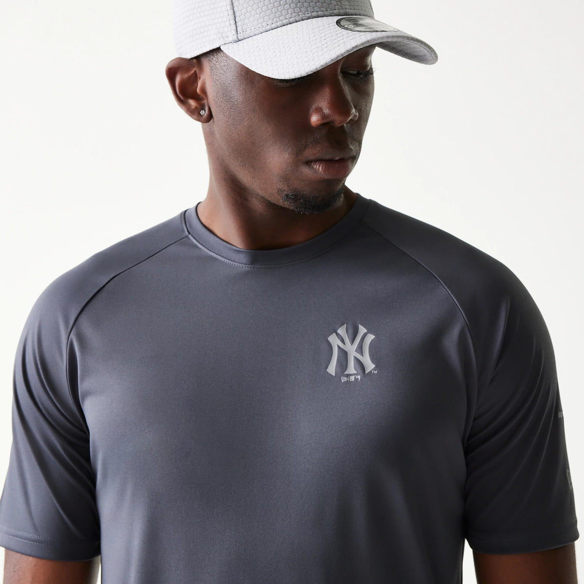 New Era New York Yankees MLB Dark Grey T-Shirt, front view on a model showing the raised New York Yankees logo centrally positioned on the chest, emphasising the clean lines and design of the short-sleeved dark grey tee.