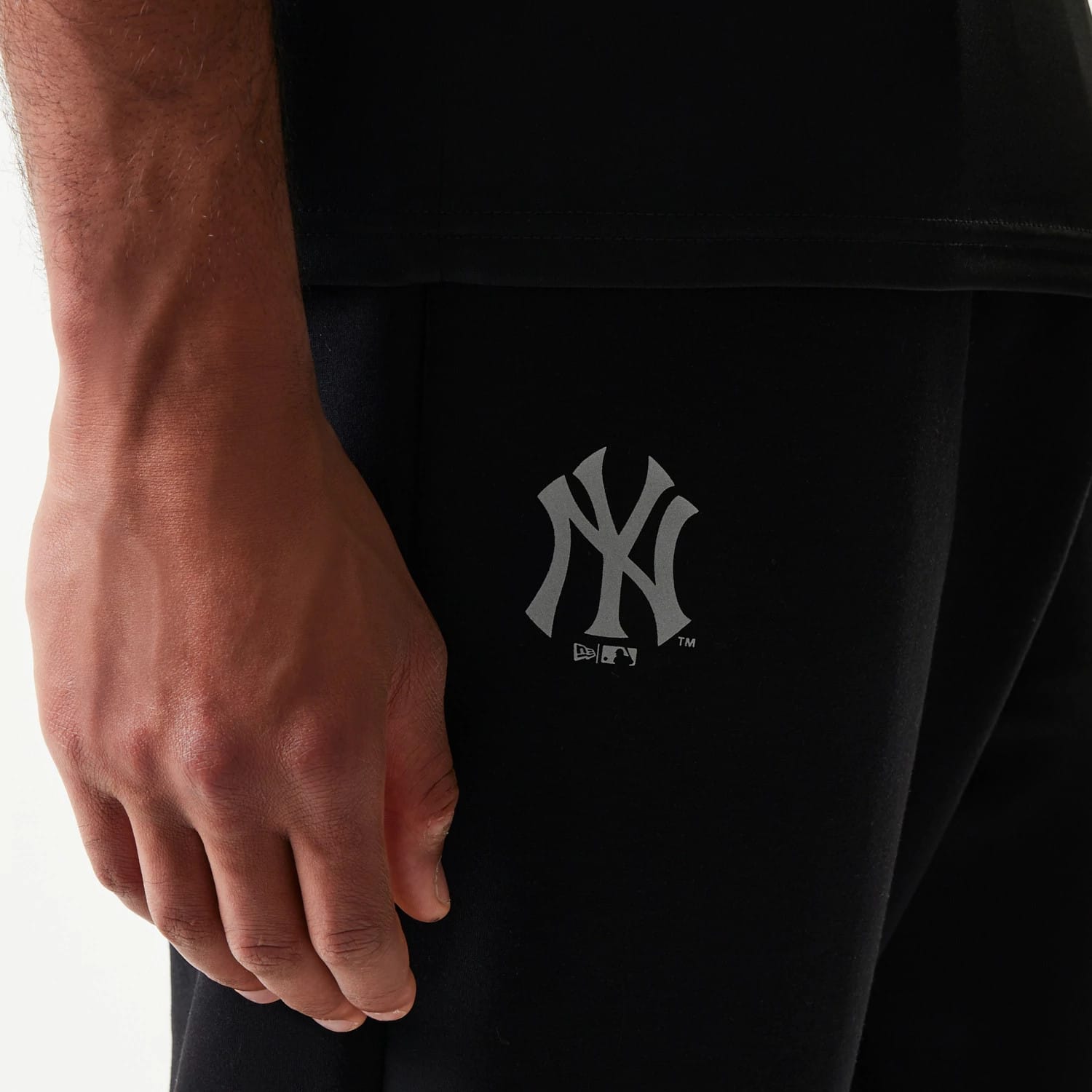 New Era New York Yankees MLB Black Joggers, close-up view showing the grey New York Yankees logo printed on the left leg, with a relaxed fit and part of the New Era branding below the team logo.