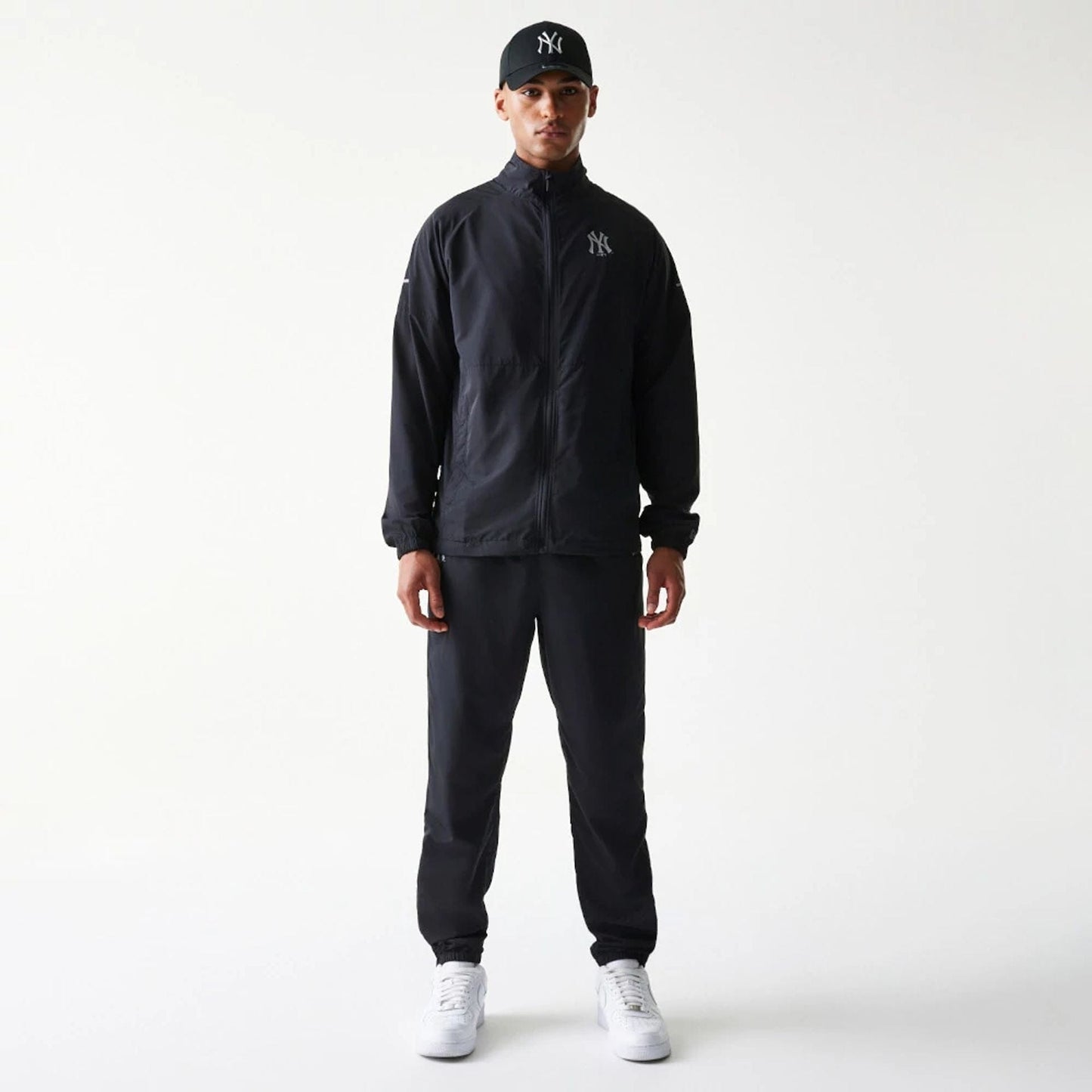 The model is wearing this MLB Reflective Logo New York Yankees Track Pants in black. 8