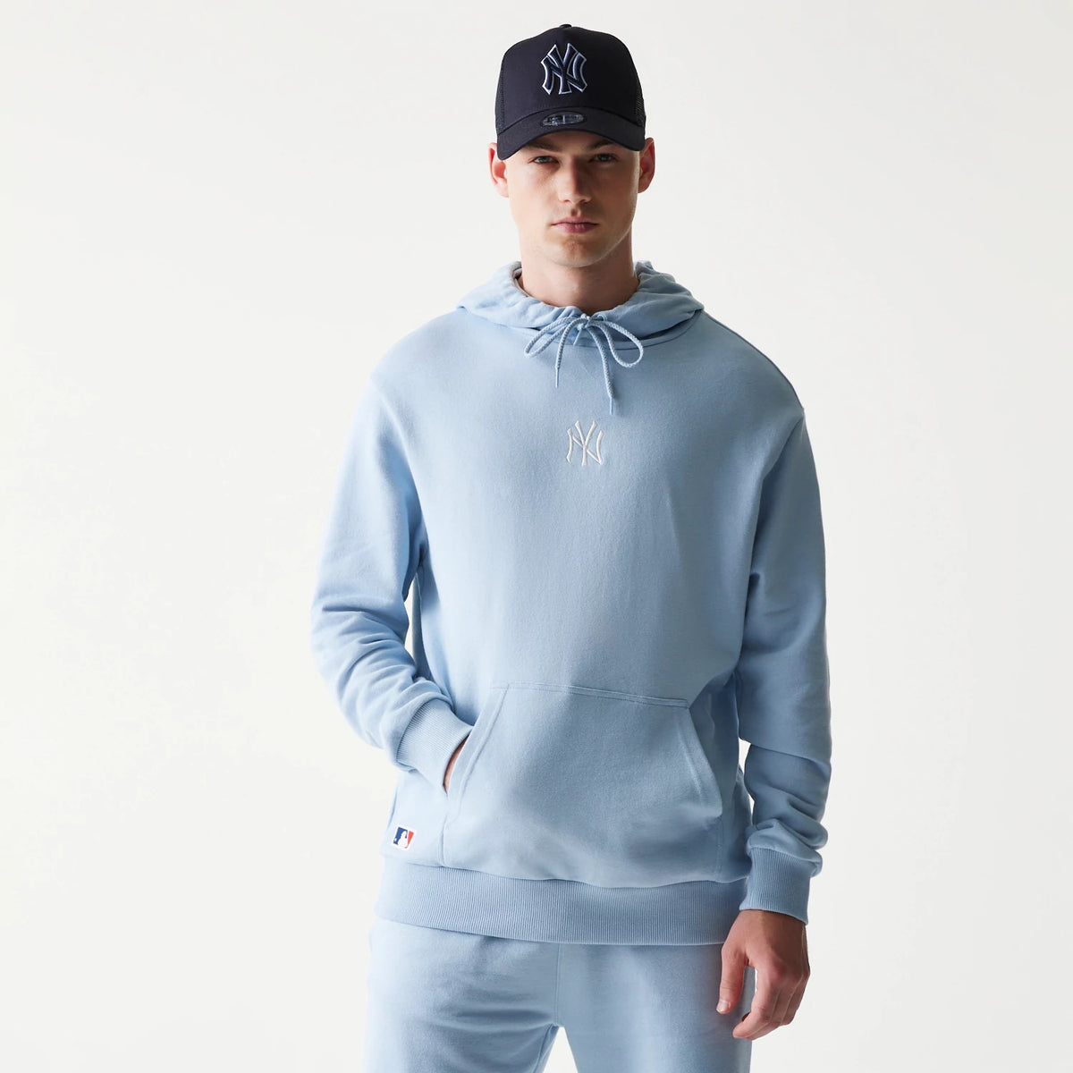 New Era New York Yankees MLB Midi Pastel Blue Oversized Pullover Hoodie, front view on-model showing the soft pastel blue hue with a raised white Yankees logo on the chest and an MLB logo patch near the hem.