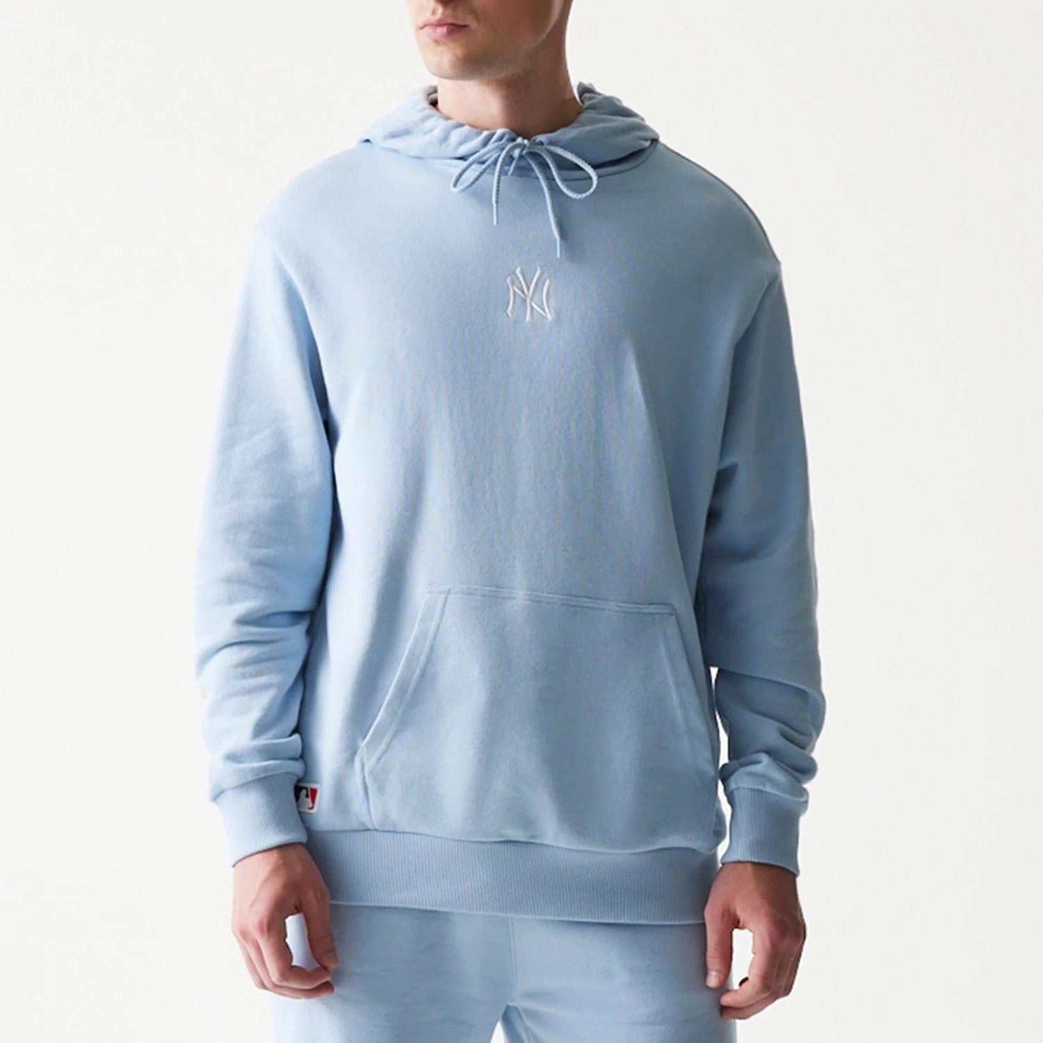 The model is wearing this MLB League Essential Midi New York Yankees Oversized Pullover Hoodie in pastel blue. 3