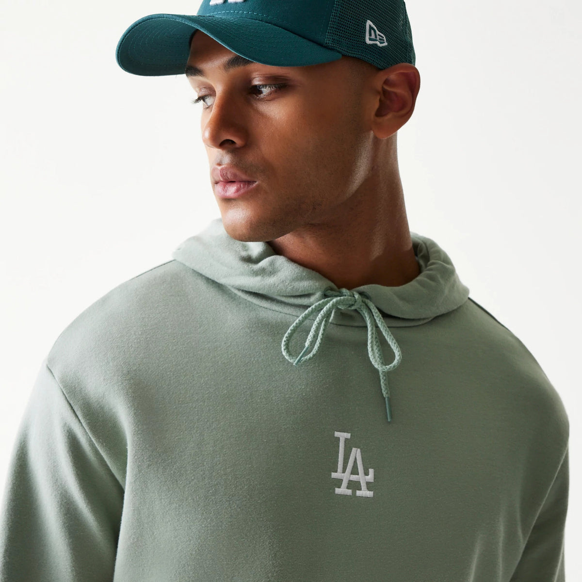 New Era LA Dodgers MLB Midi Green Oversized Pullover Hoodie, front view on a model, featuring an embroidered white LA logo on the chest with an adjustable drawstring hood and a simple, clean design.