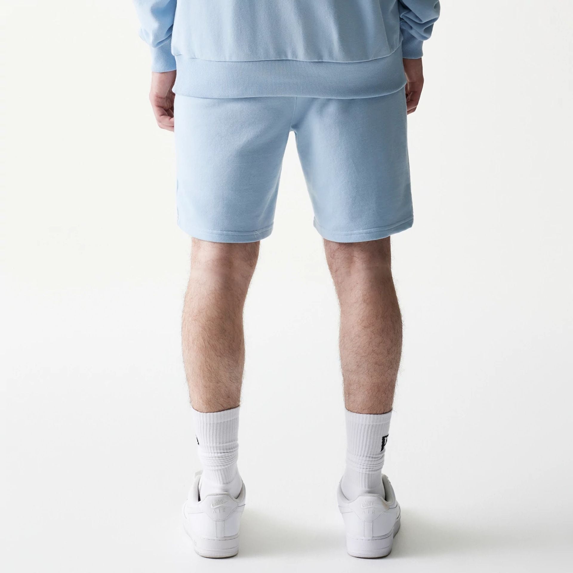 The model is wearing this MLB League Essential Midi New York Yankees Shorts in pastel blue. 2