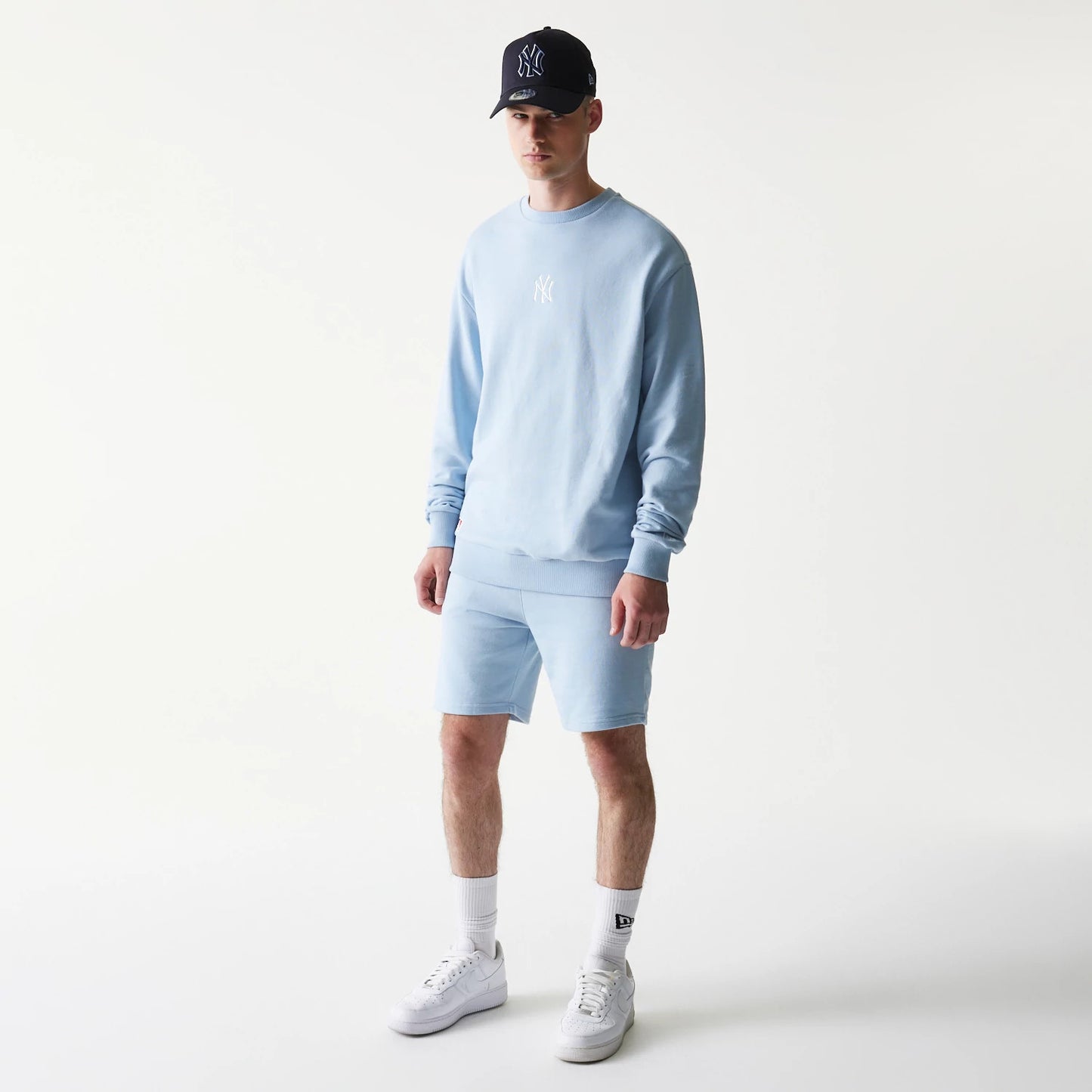 The model is wearing this MLB League Essential Midi New York Yankees Shorts in blue. 8
