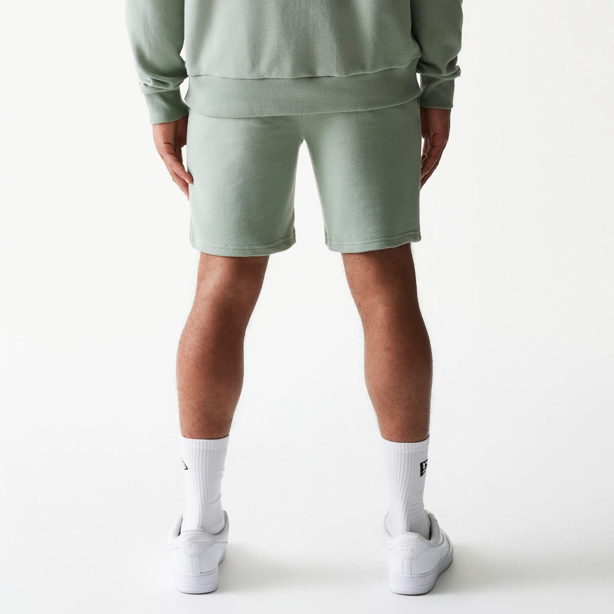 The model is wearing this MLB League Essential Midi LA Dodgers Shorts in green. 2