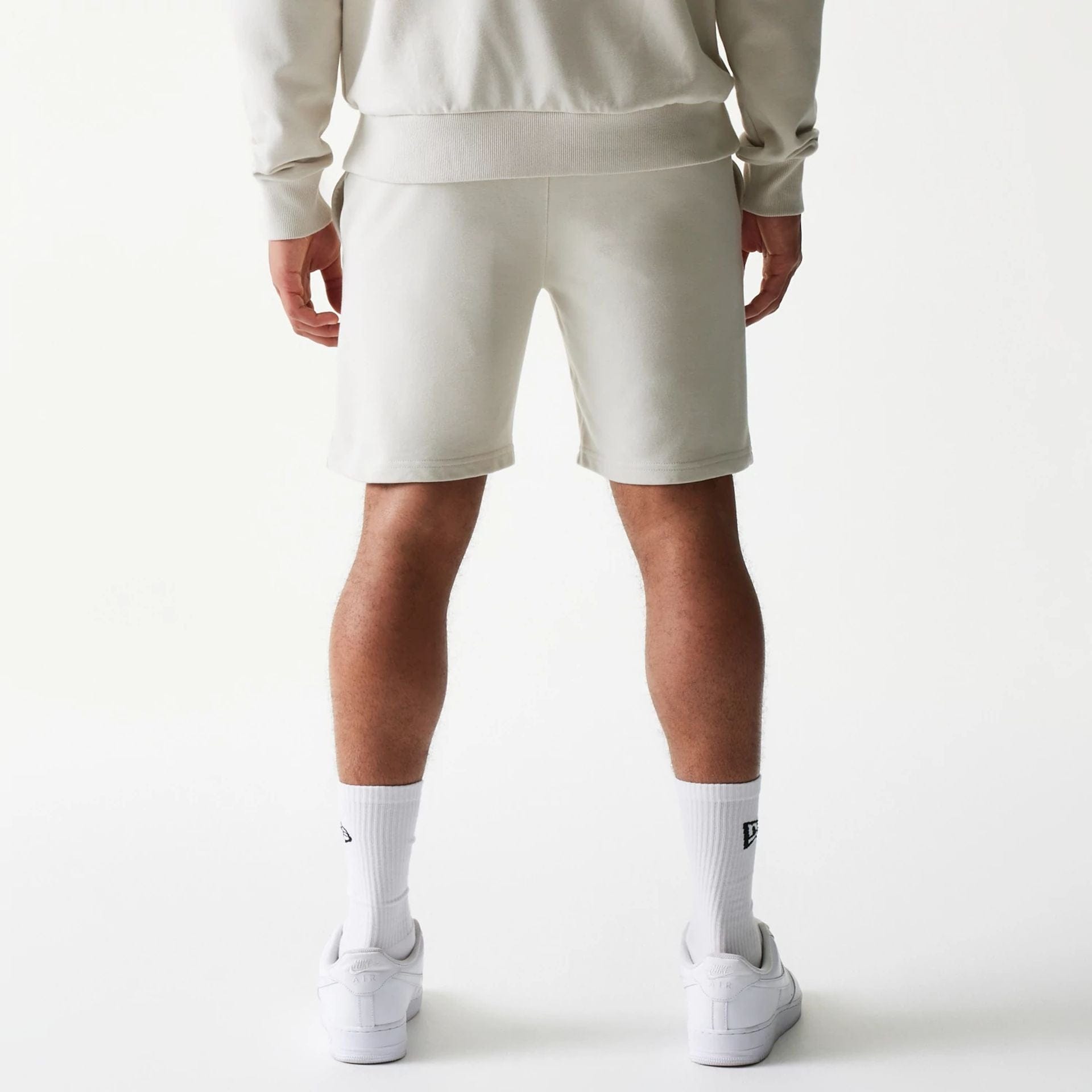 The model is wearing this NBA League Essential LA Lakers Shorts in light beige. 2