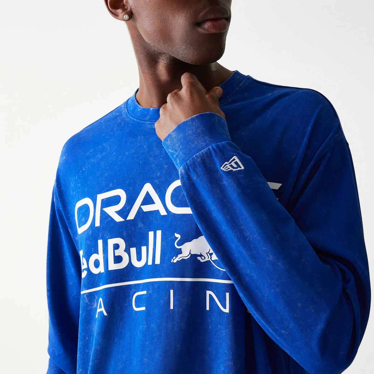 New Era Red Bull Racing Linear Graphic Blue Long Sleeve T-Shirt, front view on a model with a white printed Oracle Red Bull Racing logo across the chest and an embroidered New Era logo near the wrist on the sleeve.