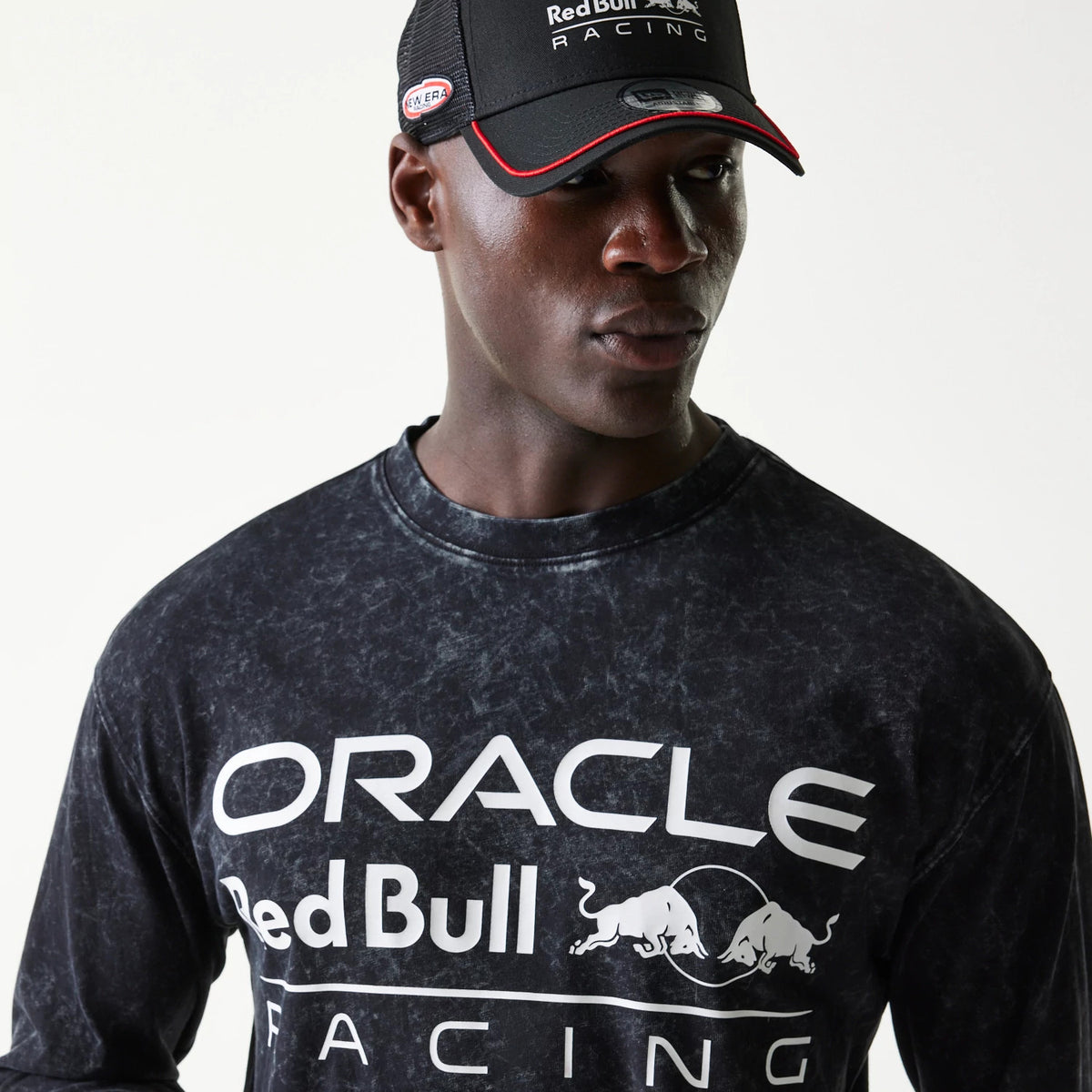 New Era Red Bull Racing Linear Graphic Black Long Sleeve T-Shirt, front view on model featuring white Oracle and Red Bull Racing lettering across the chest, with the Red Bull logo centred in between.